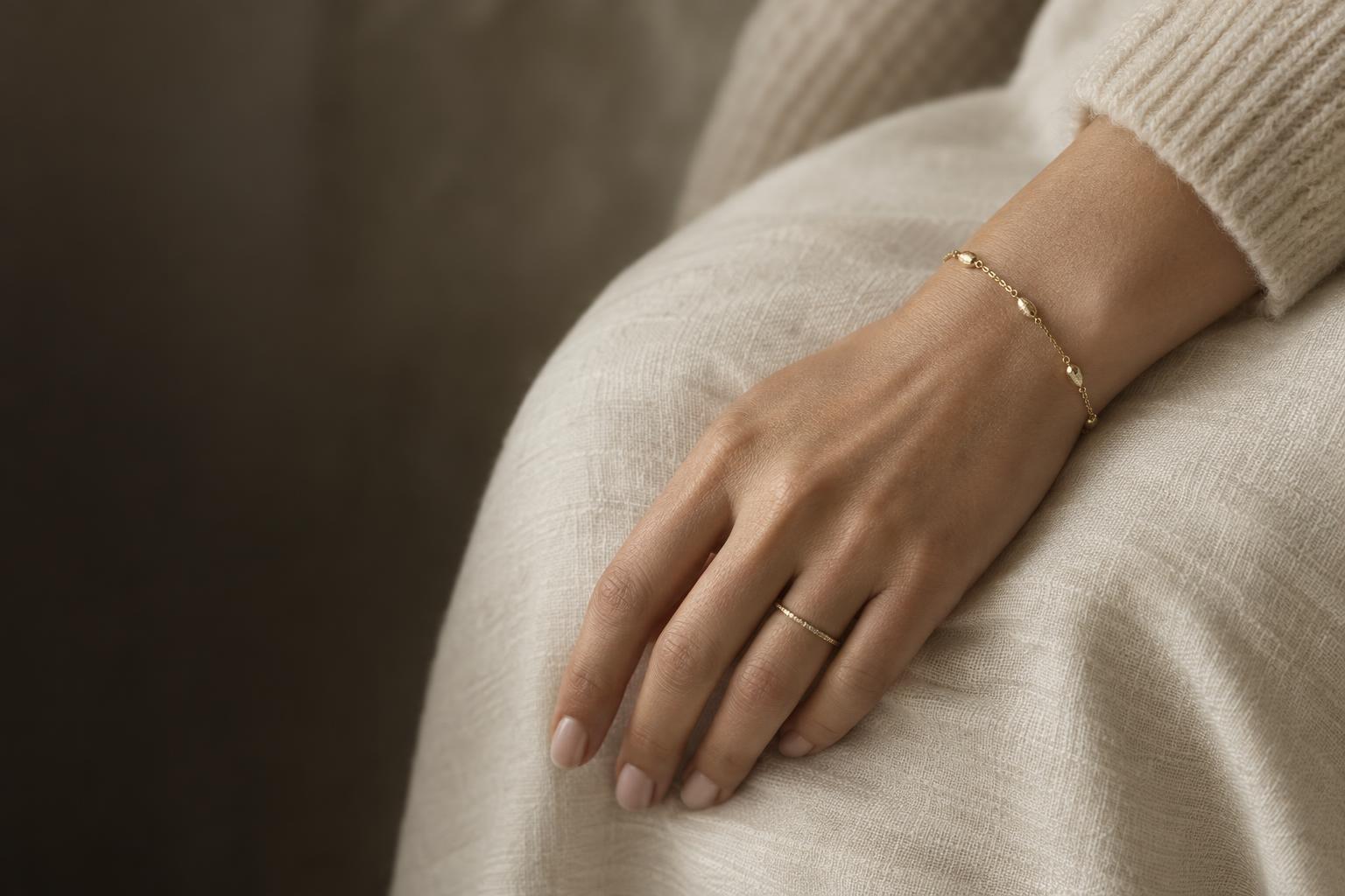 Hand med tunt guldarmband